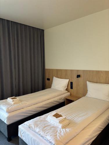 two beds in a hotel room with towels on them at MDS Bonikowo in Bonikowo