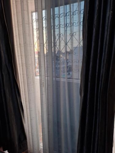 a window with a view of a building at Studio Apartment Naivas Mwembe tayari Cbd in Mombasa