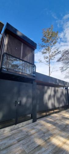 a building with a balcony with a tree in the background at Departamento Dos Ambientes En Encarnación a Estrenar in San Juan del Paraná