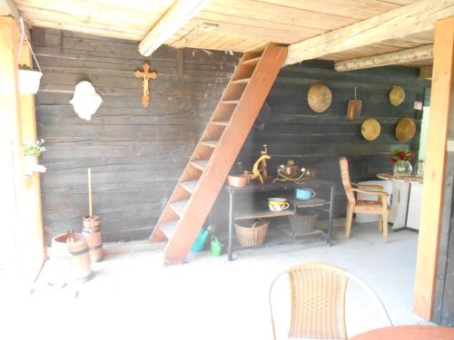 a wooden cabin with a ladder and a table at Chalupa na Valašsku in Halenkov