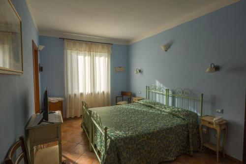 菲維札諾的住宿－Albergo Il Sicomoro，一间卧室设有一张绿色的床和一个窗户。