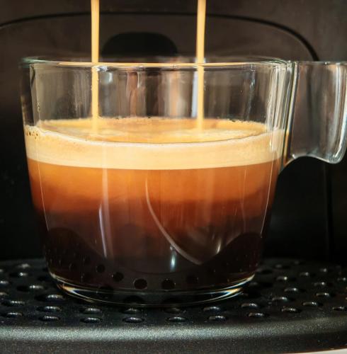 a glass cup filled with coffee sitting on a table at La Banda Suites in Seville
