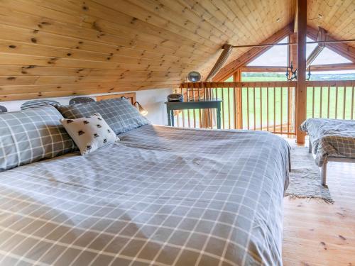 a bed in a room with a wooden ceiling at Tunturi - Cottage in Linlithgow