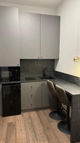 a kitchen with white cabinets and a table and chairs at Unirii Residence in Cluj-Napoca
