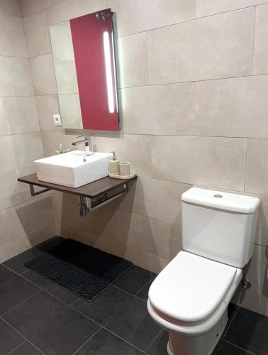 a bathroom with a white toilet and a sink at Barbastro urban home in Barbastro
