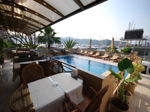 een restaurant met tafels en stoelen en een zwembad bij Hotel Doruk in Fethiye