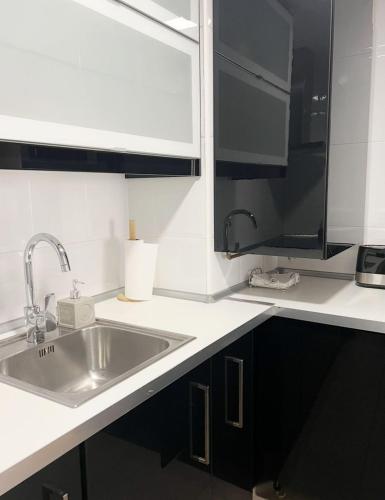 a white kitchen with a sink and a microwave at Barbastro urban home in Barbastro