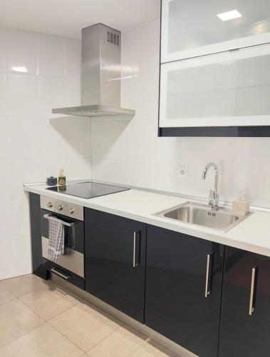 a white kitchen with a sink and a stove at Barbastro urban home in Barbastro