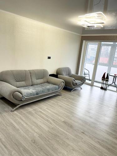 Студия 3-х комнатная ул Соборности 42 في كريفوي روغ: غرفة معيشة مع أريكة وكرسيين