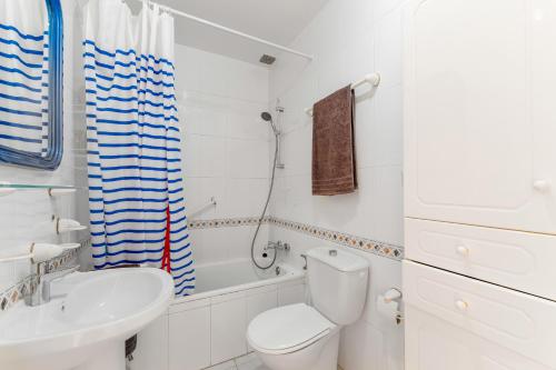 a white bathroom with a toilet and a sink at Jardin Del Mar Paraje Natural in Torrevieja