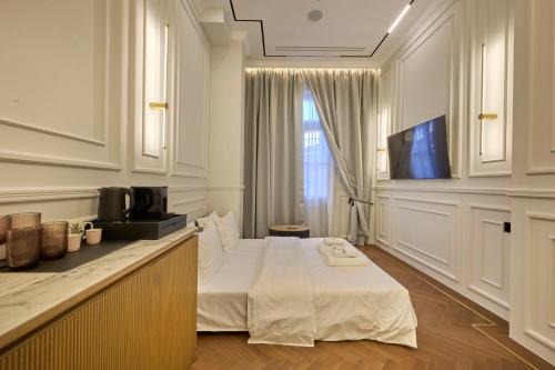 a white room with a bed and a television at Ermou 99 Intelligent Private Suites in Athens