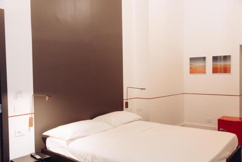 a bedroom with a white bed with a black wall at Altoledo Rooms and Suite in Naples