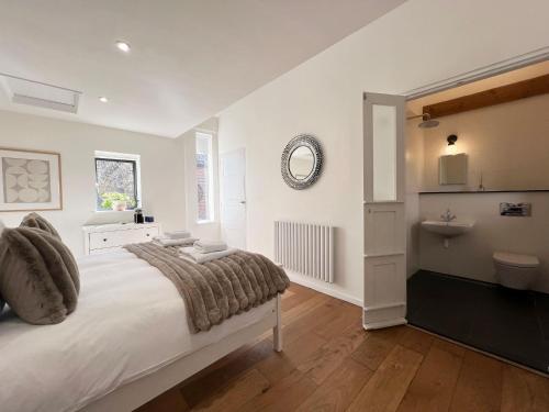 a white bedroom with a bed and a sink at Polly's Yard in Dennington