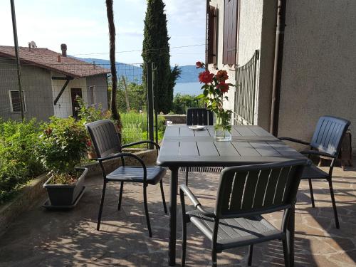 a wooden table and chairs on a patio at Apartment Maerne in Gargnano