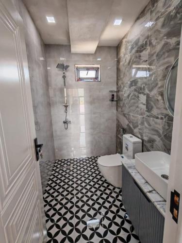 a bathroom with a black and white tiled floor at Huzoor Aframe Gabala in Gabala