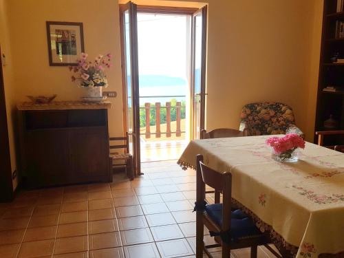 a dining room with a table with flowers on it at Apartment Maerne in Gargnano
