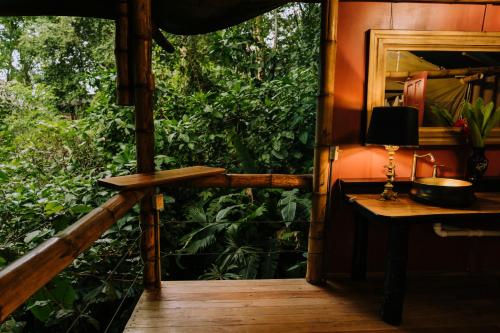 a wooden porch with a table and a mirror at Colina Secreta - Glamping and Villas in Puerto Viejo