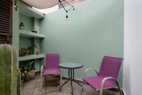 two purple chairs and a table in a room at Senda Stays Condesa in Mexico City