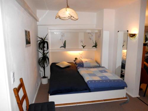 a small bedroom with a bed and a mirror at Charmantes Ferienhaus Storchenblick in Kremmen