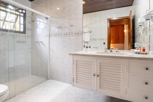 a bathroom with a shower and a sink and a toilet at Pousada Apple House Campos do Jordao in Campos do Jordão