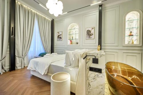 a white bedroom with a bed and a chair at Ermou 99 Intelligent Private Suites in Athens
