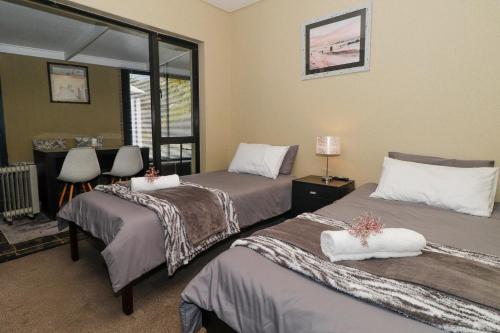 a bedroom with two beds and a window at Heathercreek Accommodation in George