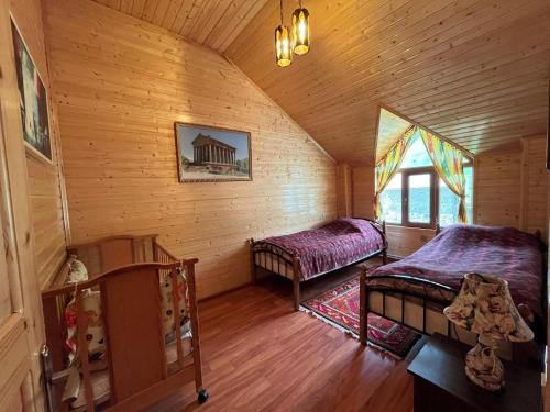 a bedroom with two beds in a wooden cabin at Shahdag Mountain Hotel in Laza