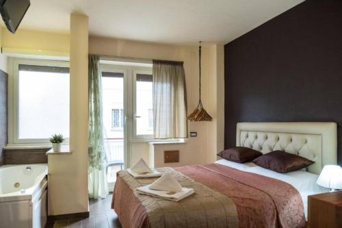 una camera da letto con un letto grande e una vasca da bagno di Aida Charming Rooms a Roma