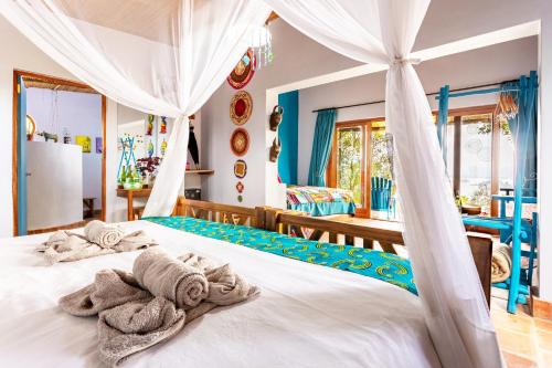 a bedroom with a bed with towels on it at Chameleon Hill Forest Lodge in Bwindi