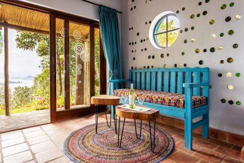 a bedroom with a blue bed and a table at Chameleon Hill Forest Lodge in Bwindi