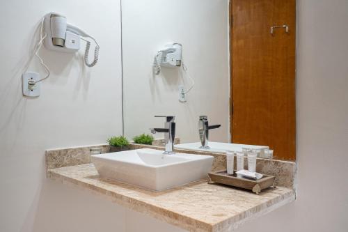 a bathroom with a white sink and a mirror at Pousada Apple House Campos do Jordao in Campos do Jordão