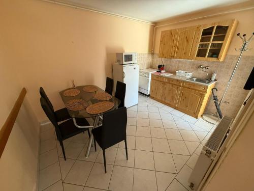 a kitchen with a table and chairs and a kitchen with a refrigerator at Réz Family Apartmanok Gyula in Gyula
