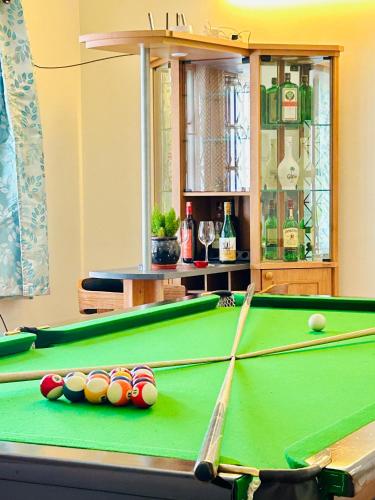 a green pool table with balls on it at Urban Escape 4BHK Luxury Villa & Sunflower Skyline 2BHK Penthouse By Spacez in Bangalore