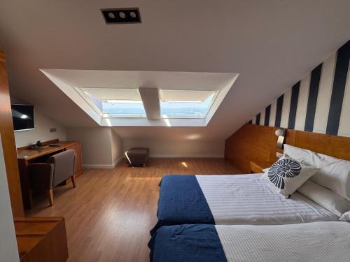 a bedroom with a bed and a skylight at Hotel O Noso Portosin in Portosin