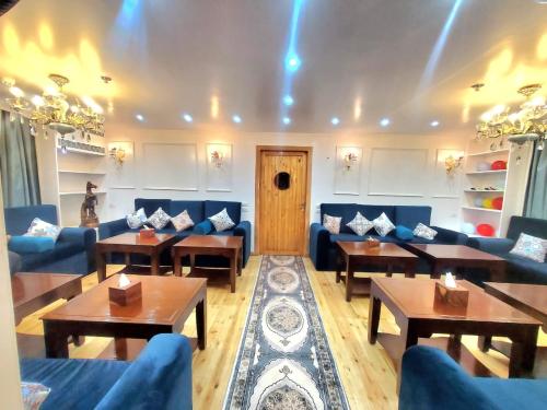 a living room with blue couches and tables and a room at Fatima Dahabiya in Luxor