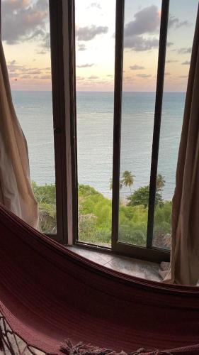 an open window with a view of the ocean at Suítes Bela Vista in Japaratinga