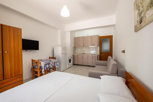 Un dormitorio con una cama y un sofá y una cocina. en Villa Oresti, en Sarandë