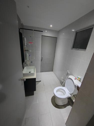 a bathroom with a toilet and a sink at Nicole Homestay in Sitiawan