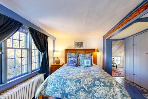 a bedroom with a bed with a blue and white bedspread at Water Street Retreat in Sandwich