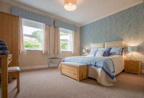 a bedroom with a bed and a blue wall at Sea View Lodge in Nairn