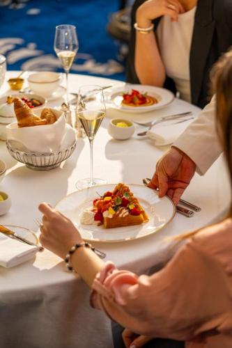 a group of people sitting at a table with a plate of food at Corinthia Grand Hotel du Boulevard Bucharest in Bucharest