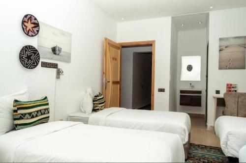 a white room with two beds and a couch at W hotel in Dakhla