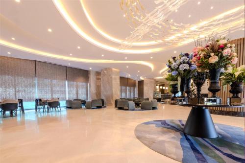a lobby with chairs and flowers on a table at Radisson Hotel Istanbul Merter in Istanbul
