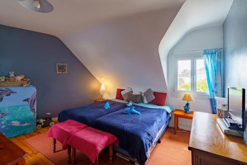 ein Schlafzimmer mit einem blauen Bett und einem Fenster in der Unterkunft Ty Provans e Breizh - Maison pour 12p in Primelin