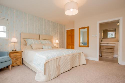 a bedroom with a large bed and a blue wall at Sea View Lodge in Nairn