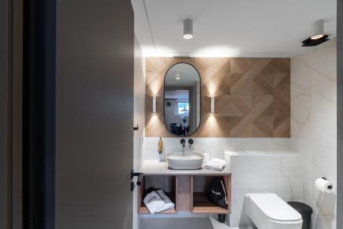 a bathroom with a sink and a mirror at Balice Apartamenty Premium - by Upstairs in Cholerzyn