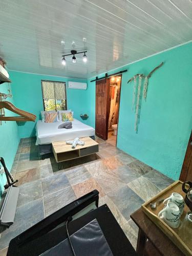 a living room with a bed and a table in a room at Boutique Rooms River Front at La Junta in Dominical