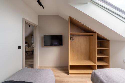 a bedroom with a built in closet and a tv at Balice Apartamenty Premium - by Upstairs in Cholerzyn