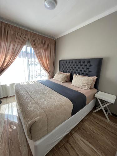 a bedroom with a large bed and a window at Mont Pelaan 88 in Newcastle