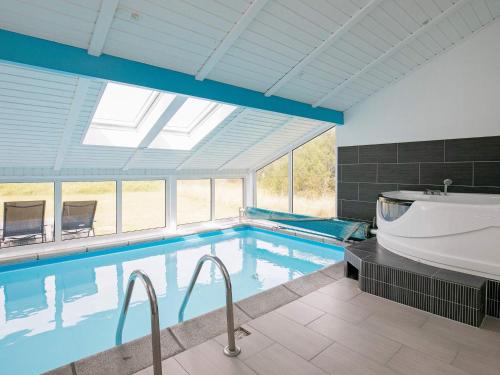 a large swimming pool with a tub and a bath tub at 8 person holiday home in Løkken in Løkken